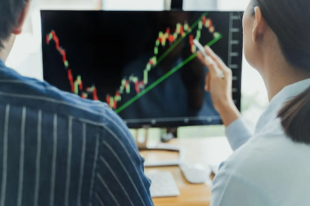 Homem e mulher analisando métricas em um computador.