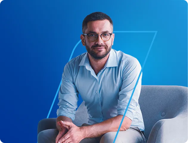 Na imagem, temos um homem sentado em uma poltrona azul clara