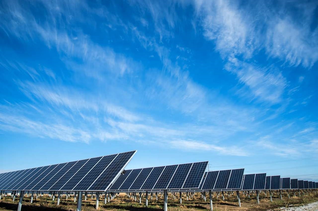 Painéis solares instalados em um campo amplo apontados para o céu para gerar tipos de energia solar.