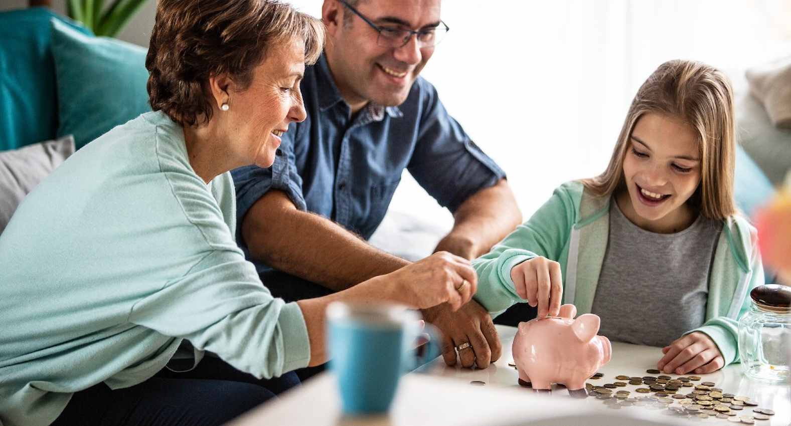 A imagem mostra uma família colocando moedas em um cofre.