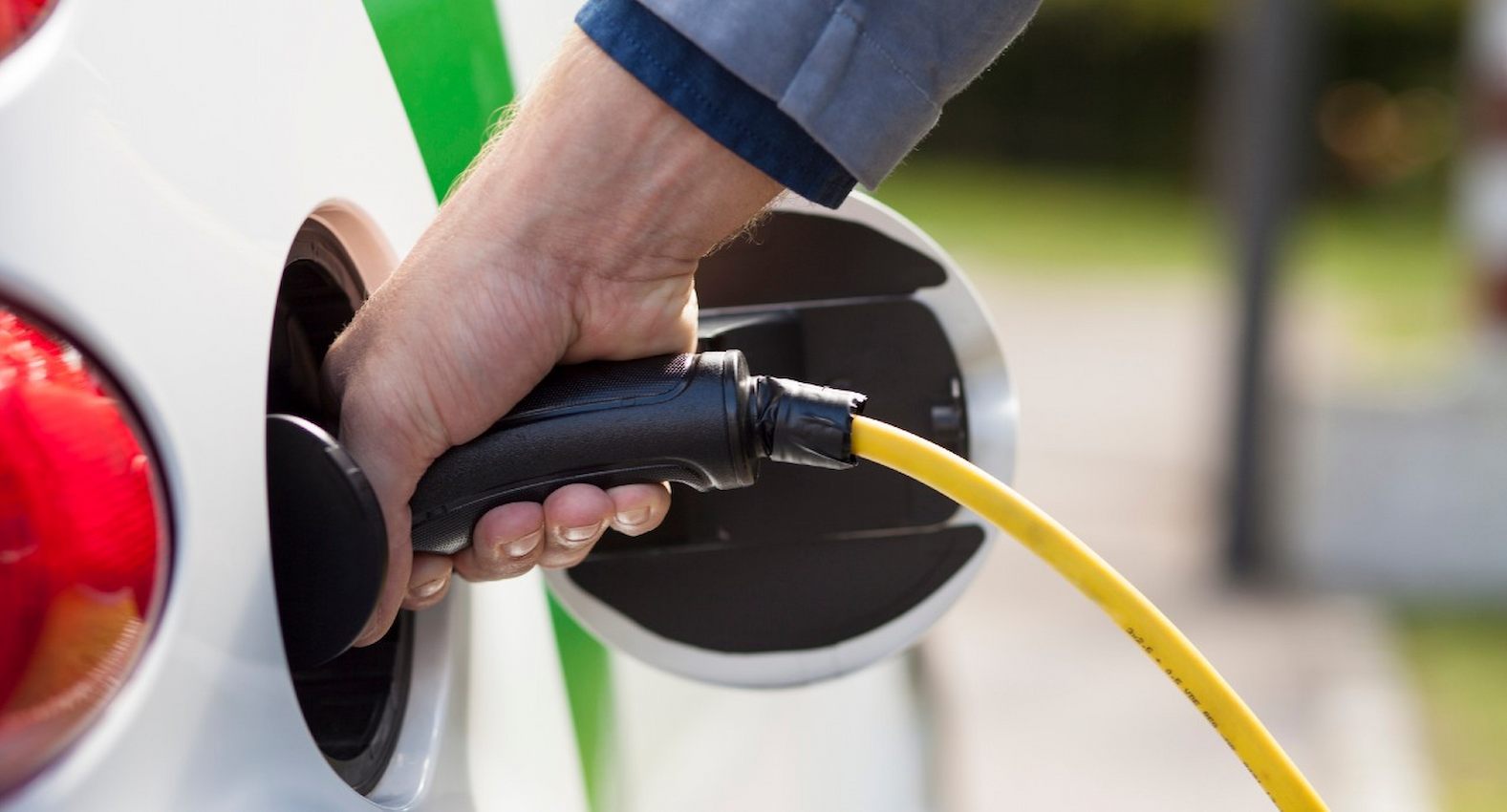 A imagem mostra um carro elétrico sendo carregado.