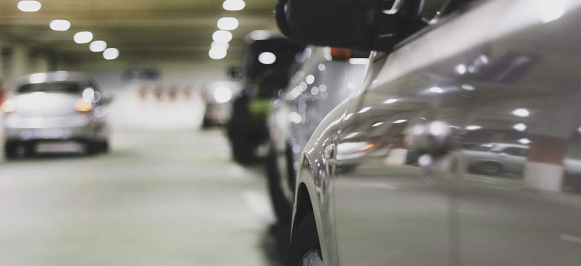 A imagem mostra a lateral de um carro e vários outros em sua frente.