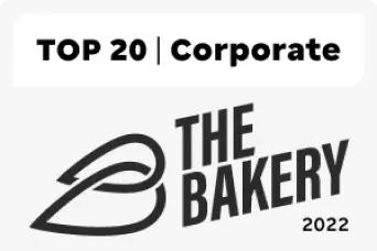 Imagem de um texto, em que o título é TOP 10 Corporate, na cor preta. Abaixo, há a palavra The Bakery também na cor preta com o número 2022. Ao lado, aparecem duas imagens em formato de gota, sendo uma maior do que a outra, interlaçadas e deitadas para o lado esquerdo.