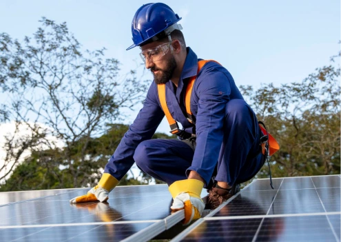 Homem com capacete e óculos de proteção, instalando painéis solares.