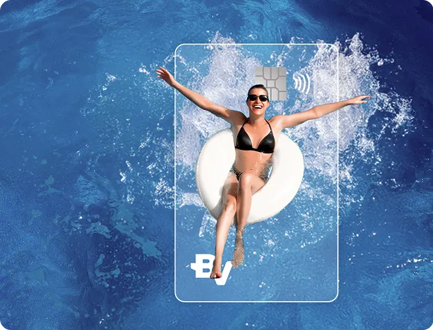 Mulher de braços abertos deitada em cima de uma bóia redonda e branca em piscina com águas azuis