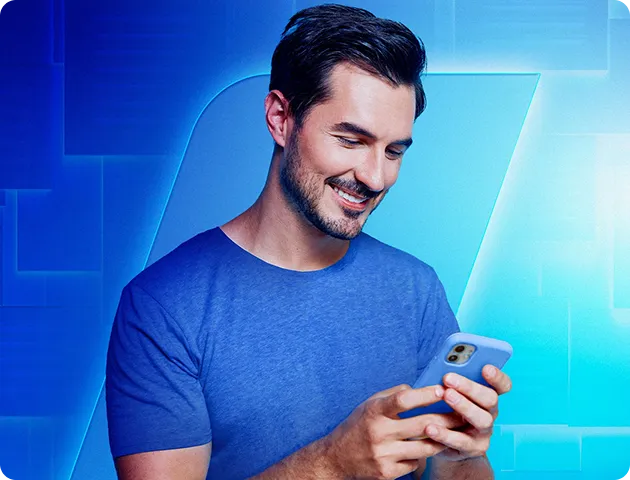 Em um fundo azul com a haste do BV, um homem segura o celular enquanto o olha e sorri.