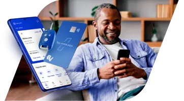 homem negro, sorrindo, deitado em seu sofá e mexendo no celular. Ao lado esquerdo do homem, temos a composição com a tela de um celular mostrando o app BV, com a chave de um carro e com um dos Cartões BV. 