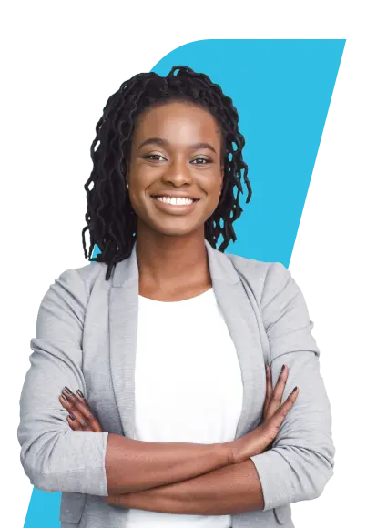 A imagem mostra uma mulher com cabelo escuro, com dreads médios, sorridente com os braços cruzados. Ela veste um blazer cinza claro sobre uma blusa branca.