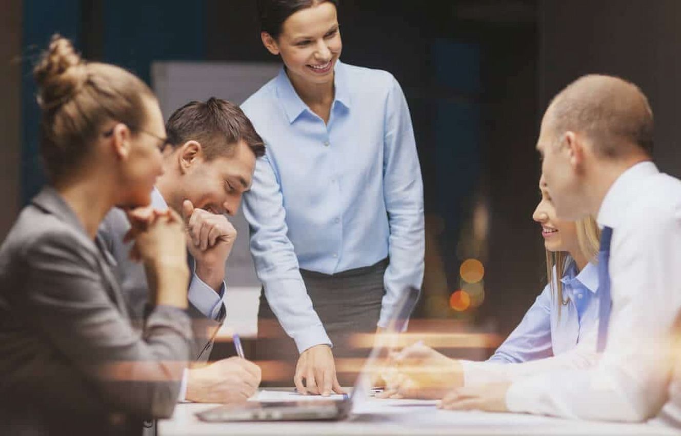 A imagem mostra um grupo de pessoas em reunião em uma empresa.